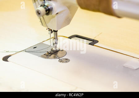 Il piedino di macchine per cucire. Macchina da cucire sul posto di lavoro.ABBIGLIAMENTO, designer atelier, processo di sartoria.Il fuoco selettivo.spazio copia.Sarto workshop.Tecnologia, materiali, attrezzature concetto. Foto Stock