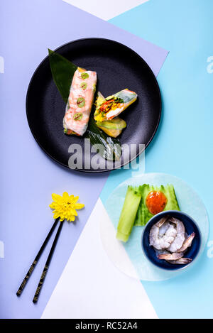 Fresh Asian involtini primavera con gamberetti, verdura e frutta avvolto in carta di riso. Vista superiore, laici piatta Foto Stock