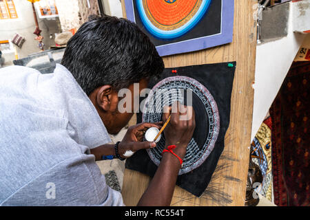 Leh, India - 24 agosto 2018: l'uomo il disegno di una circolare simbolo buddista nelle strade di Leh. Editoriale illustrativa. Foto Stock