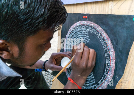 Leh, India - 24 agosto 2018: uomo di disegno di un simbolo buddista nelle strade di Leh. Editoriale illustrativa. Foto Stock