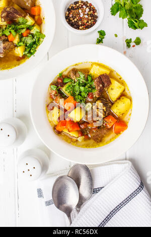 Tedesco tradizionale zuppa eintopf con carne, legumi e verdure in una piastra bianca, vista dall'alto. Foto Stock