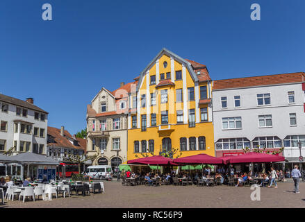 Le persone che si godono il sole presso la vecchia piazza del mercato nella città di Herford, Germania Foto Stock