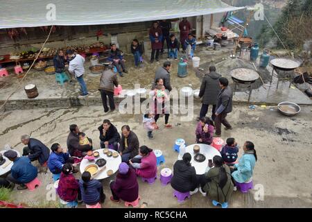 GUIZHOU, Cina - circa nel dicembre 2018: persone di diversi gruppi etnici sedersi insieme in occasione della festa di nozze. Foto Stock