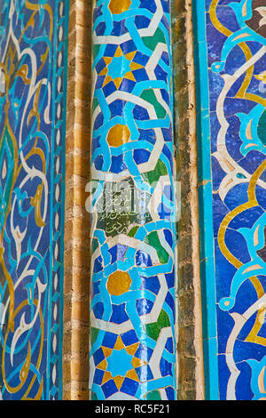 YAZD, IRAN - 18 ottobre 2017: Il close-up del snella colonna della moschea Jameh il mihrab con raffinati modelli islamici di piastrelle e intricati calligrap Foto Stock