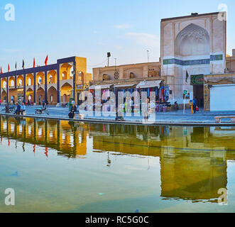 YAZD, IRAN - 18 ottobre 2017: la fontana di Amir Chakhmaq square riflette la platea del turista bazaar, galleria arcuata e il portale di Dahouk Foto Stock