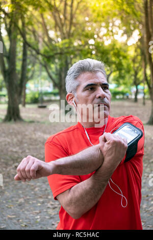 Un uomo maturo stretching nel parco di Ibirapuera, Sao Paulo, Brasile Foto Stock