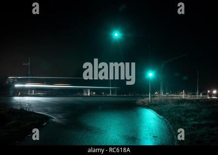 Semaforo verde mostrando la luce nella notte bagnata. Foto Stock