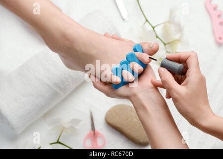 Pedicurist l'applicazione di smalto trasparente Foto Stock