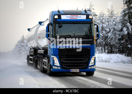 Salo, Finlandia - 23 dicembre 2018: Volvo FH trasporto alla rinfusa carrello anteriore di guida su strada innevata in condizioni artiche con fari abbaglianti brevemente Foto Stock