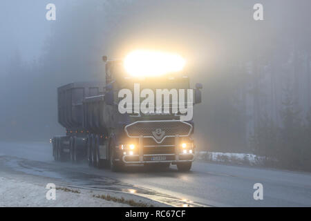 Salo, Finlandia - 28 dicembre 2018: fari abbaglianti di Scania V8 superdump carrello su autostrada rurale su un molto nebbioso giorno di inverno nel sud della Finlandia. Foto Stock