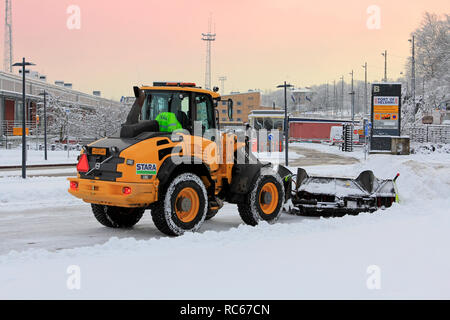 Helsinki, Finlandia - 9 Gennaio 2019: rimozione della neve con Volvo L50G pala caricatrice gommata compatta dotata di spartineve vicino al porto di Helsinki il giorno dell'inverno. Foto Stock