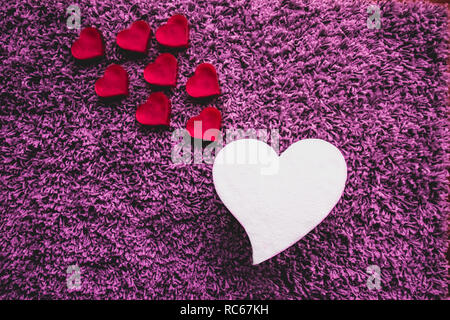 Grande cuore bianco con piccoli cuori rosa andando verso l'alto. Foto Stock