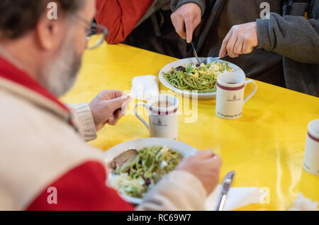 Stuttgart, Germania. Xiii gen, 2019. Due uomini di mangiare durante il primo giorno dei Vespri della Chiesa. Per la venticinquesima volta la più antica chiesa Vesper in Germania fornisce persone bisognose con pasti caldi e più per sette settimane. Credito: Sebastian Gollnow/dpa/Alamy Live News Foto Stock