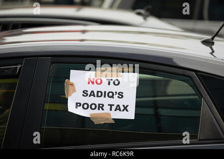 London, Regno Unito - 14 GEN 2019: un segno di protesta attaccato ad un minicab bloccando la strada al di fuori TFL uffici in una dimostrazione contro la congestione del traffico le tasse. Credito: Kevin J. Frost/Alamy Live News Foto Stock