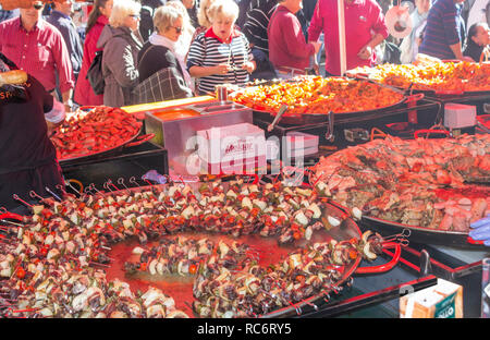 Campillos, Malaga, Spagna. Prosciutto e salumi la fiera. Grandi pentole di salsicce, chorizo e altra carne di maiale prodotti correlati sono serviti a molti visitatori Foto Stock