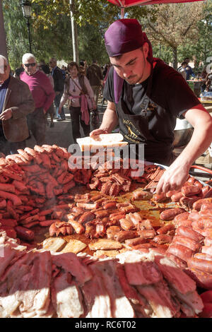 Campillos, Malaga, Spagna. Prosciutto e salumi la fiera. Grandi pentole di salsicce, chorizo e altra carne di maiale prodotti correlati sono serviti a molti visitatori Foto Stock