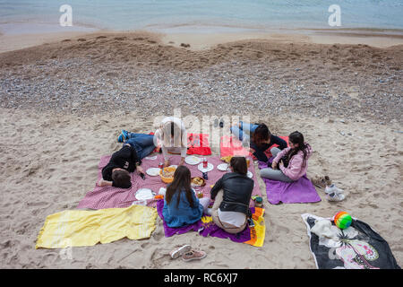 Un gruppo di giovani aventi picnic su una spiaggia a Villefranche sur Mer in Francia, località di villeggiatura al mare Mediterraneo sulla Costa Azzurra - La costa azzurra Foto Stock