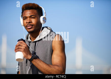 Malinconici sporty guy rinfrescante dopo il corso di formazione Foto Stock
