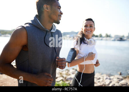 Energetico eccitato giovane in chat e jogging Foto Stock