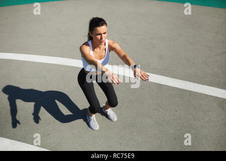 Donna facendo squat stadium Foto Stock