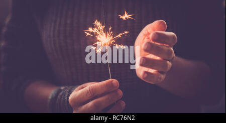 La celebrazione di eventi e il concetto di partito primo piano della coppia di mani che prendono e uso di botti fuochi d'artificio di luce e divertimento - medioevo donna celebrare bi Foto Stock