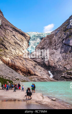 Norvegia, Olden - 1 Agosto 2018: le persone al vicino lago e Briksdal o Briksdalsbreen ghiacciaio con la fusione del ghiaccio blu, natura punto di riferimento Foto Stock