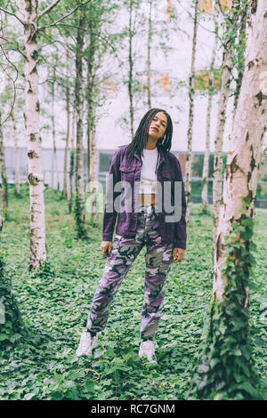 Donna in piedi su ivy tra argento betulla Foto Stock
