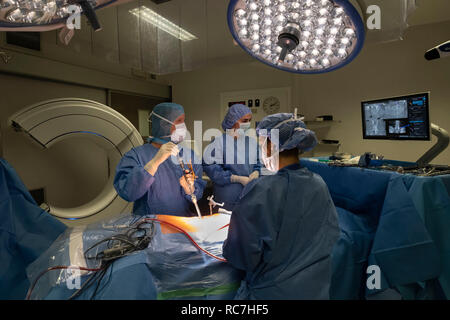 I medici guardando il neuronavigation assistita da calcolatore sistema di tecnologia schermo durante la chirurgia della colonna vertebrale Foto Stock