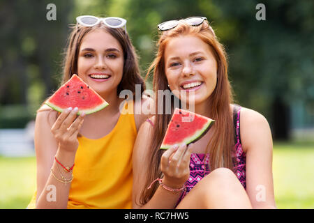 Le ragazze adolescenti mangiando anguria a picnic nel parco Foto Stock