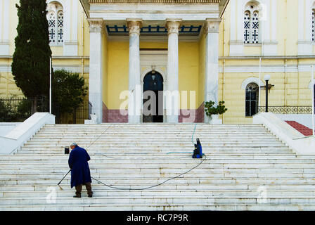 La pulizia dei passi della Chiesa di St Nicholas nel porto del Pireo, Grecia Foto Stock