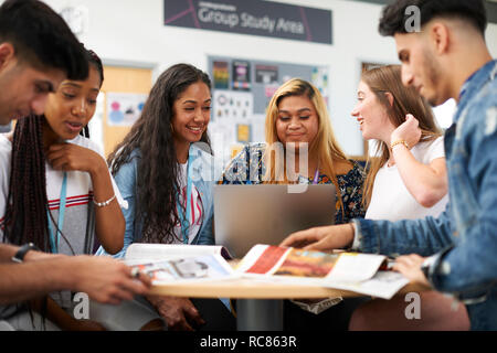 Maschio e femmina di istruzione superiore gli studenti a discutere di progetto in college classroom Foto Stock