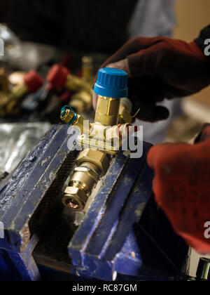 Uomo al lavoro con raccordo in metallo Foto Stock