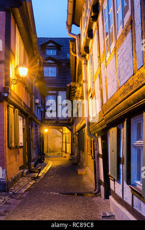 Luce di lanterne in stretti vicoli medievali lungo la metà-case con travi di legno nella città vecchia di Quedlinburg in Germania Foto Stock