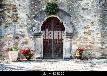 Porta di ingresso alla missione Espada in San Antonio Texas su una luminosa giornata soleggiata con decorazioni di Natale - rustico in legno porta Foto Stock