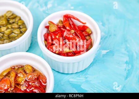 Conserve Italia - set marinata di capperi e pepe, pomodori secchi in bianco a bocce. Mediterraneo. Copia dello spazio. Foto Stock