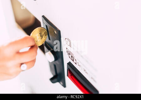 Il denaro quotidiano utilizzo macchina automatica mano inserire bitcoin per acquistare e pagare servizi - futuro del commercio e business con cryptocurency e virtual mone Foto Stock