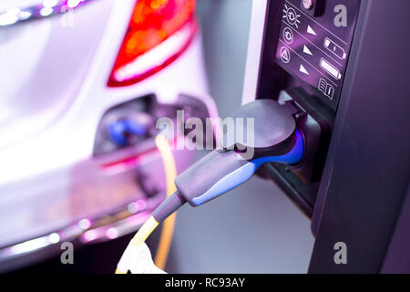 Alimentazione collegare al veicolo elettrico per la carica della batteria. La tecnologia di caricamento trasporti industria che sono la futuristica dell'automobile. Foto Stock