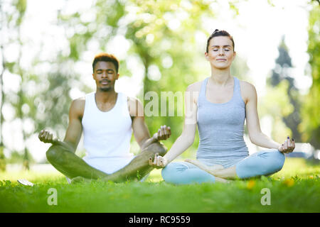 Giovane uomo e donna a praticare yoga all'aperto Foto Stock