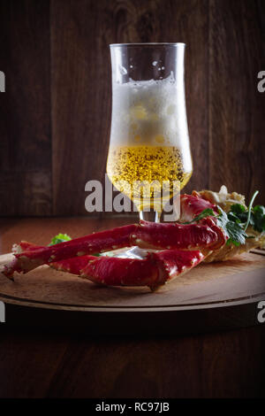 Red king crab gambe con lbeer su un tavolo rustico Foto Stock