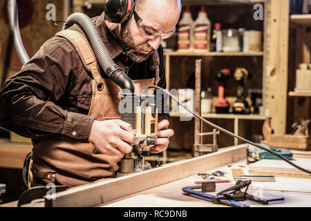 Falegname caucasica al lavoro nel suo laboratorio Foto Stock