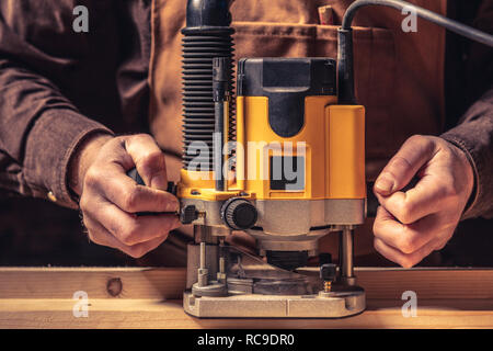 Falegname caucasica al lavoro nella sua bottega dettaglio del router Foto Stock