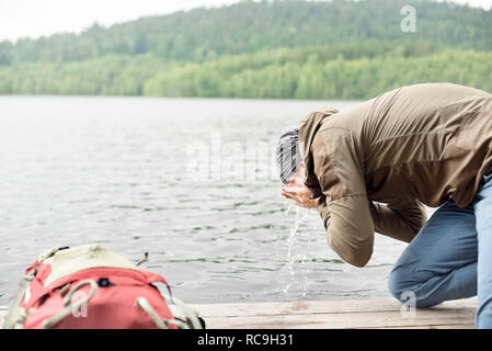 Escursionista faccia il lavaggio nel lago Foto Stock