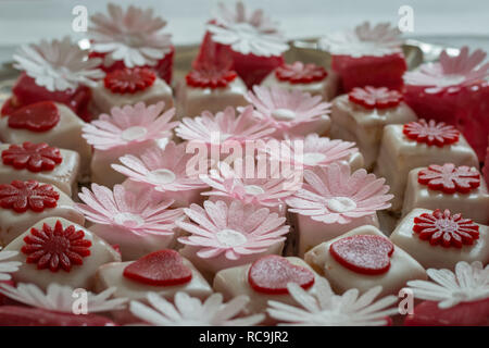 Colorato petit fours con decorazioni di fiori Foto Stock
