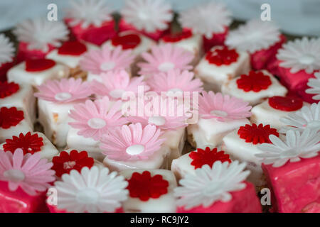 Colorato petit fours con decorazioni di fiori Foto Stock