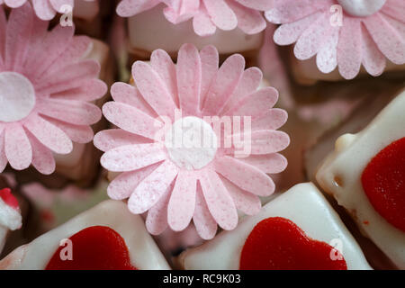 Colorato petit fours con decorazioni di fiori Foto Stock