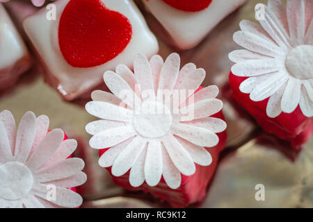 Colorato petit fours con decorazioni di fiori Foto Stock