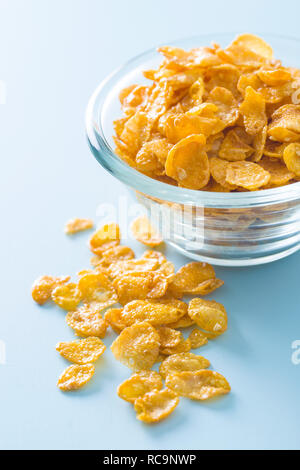 Cereali per la prima colazione o cornflakes nella ciotola su sfondo blu. Foto Stock