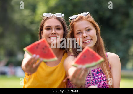 Le ragazze adolescenti mangiando anguria a picnic nel parco Foto Stock