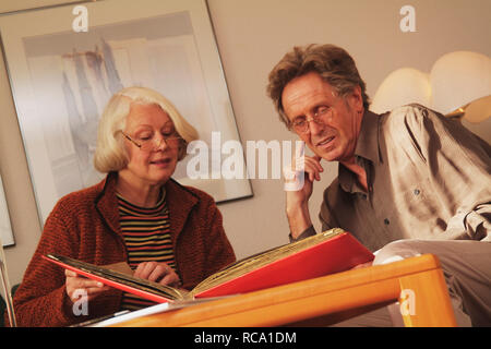 Pärchen mittleren altera schaut sich Fotoalbum un | middleaged giovane è alla ricerca di album di foto Foto Stock