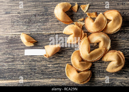 Incrinato Fortune cookie con carta bianca sul tavolo di legno Foto Stock